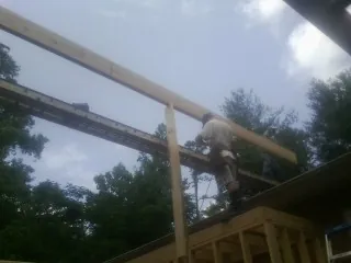 Carpenter setting a ridge beam over a new addition frame — Ice Dam Removal by Roofing Brothers in New Harmony