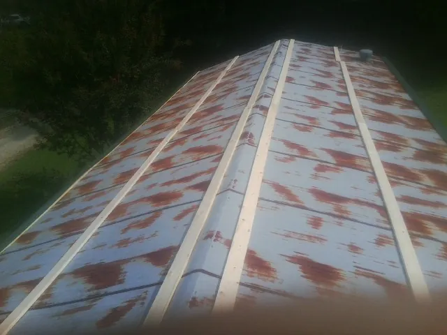 Rusted metal roof panels with new wood purlins before replacement — Storm Damage Roof Repair in New Harmony by Roofing Brothers