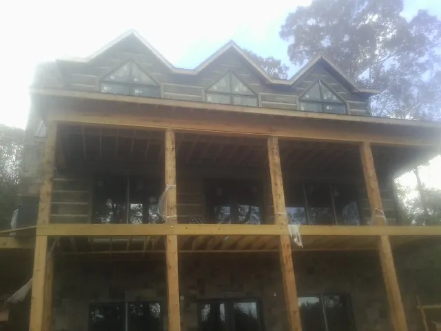 Dormers and porch framing on a large log home under construction — Roof Coating work by our crew in New Harmony