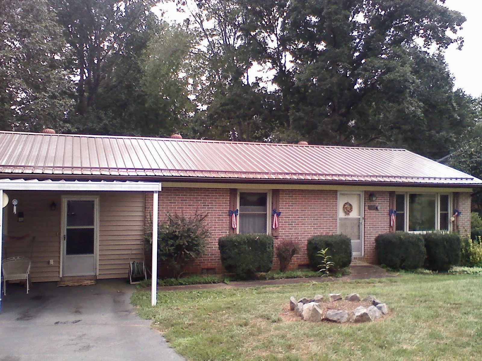 Bronze metal roof and carport on a brick ranch home — Roof Repair work by our crew in New Harmony